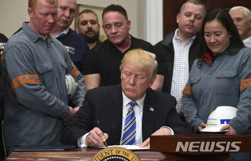 【워싱턴=AP/뉴시스】도널드 트럼프 미 대통령이 8일(현지시간) 백악관 루스벨트 룸에서 미 철강 노동자들이 지켜보는 가운데 미국으로 수입되는 철강과 알루미늄에 높은 관세를 부과하는 행정명령에 서명하고 있다. 2018.3.9