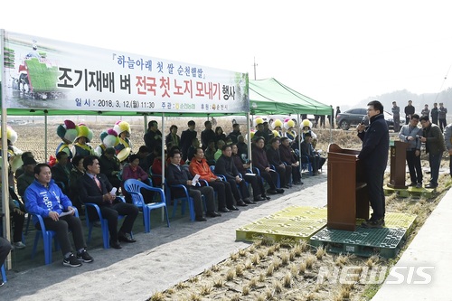 【순천=뉴시스】김석훈 기자 = 전남 순천시는 12일 해룡면 신대리 신성마을 백인기(51)농민의 0.3㏊ 논에서 농업인, 공무원, 농협관계자 등 100여명이 참석한 가운데 올해 전국 첫 노지 모내기를 실시했다고 밝혔다. 2018.03.12. (사진=순천시청 제공) kim@newsis.com