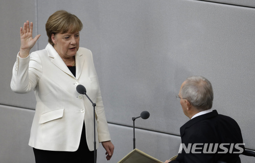 【베를린=AP/뉴시스】 독일의 앙겔라 메르켈 총리가 14일 연방 하원에서 투표로 총리로 뽑힌 뒤 볼프강 쇼이블레 하원의장 앞에서 4번째 총리직 취임 선서를 하고 있다. 휠체어를 타고 있는 쇼이블레 의장은 지난 총선 전까지 8년 동안 메르켈 총리 내각의 재무장관으로 독일 경제 정책을 움직였다. 2018. 3. 14. 