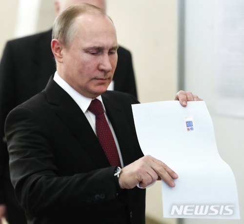 【모스크바=AP/뉴시스】블라디미르 푸틴 러시아 대통령이 18일(현지시간) 모스크바에서 대통령 선거 투표용지를 투표함에 넣고 있다. 2018.3.18