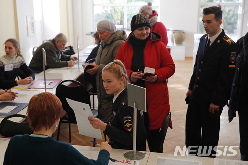 【모스크바=AP/뉴시스】러시아 유권자들이 18일(현지시간) 모스크바 투표소에서 투표 용지를 받기 위해 순서를 기다리고 있다. 2018.03.18