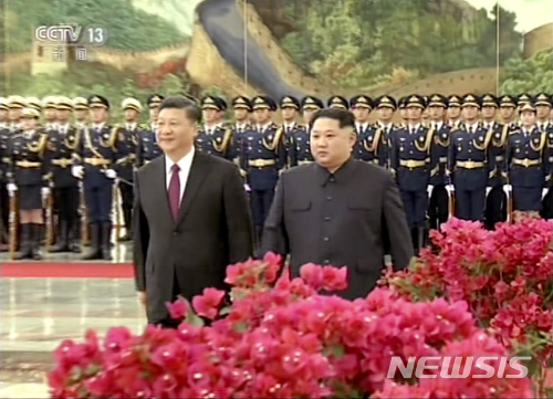 【베이징=CCTV·AP/뉴시스】시진핑 중국 국가주석이 26일 김정은 북한 노동당 위원장과 함께 베이징 인민대회당에서 열리는 환영식에 참석하고 있다. 댜오위타위 국빈관으로 보이는 곳의 정원을 걷고 있다. 28일 중국 신화통신은 김 위원장의 방중 사실을 공식 보도했다. 사진은  이날 관영 CCTV가 방송한 영상을 캡처한 것이다. 2018.03.28