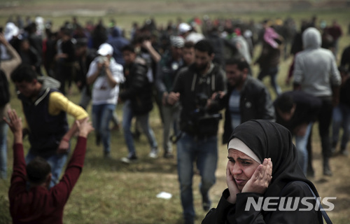 【가자=AP/뉴시스】 30일 가자 봉쇄펜스 부근에서 행진 시위에 참여한 한 팔레스타인 여성이 이스라엘 군인의 사격 소리에 귀를 막고 있다. 2018. 3. 30.  