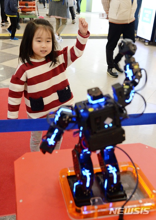 【전주=뉴시스】윤난슬 기자 = 8일 오후 전북 전주월드컵경기장에서 '국제 3D프린팅·드론 코리아 엑스포'가 열린 가운데 행사장에서 한 아이가 춤추는 로봇을 보며 춤을 추고 있다. 2018.04.08. yns4656@newsis.com