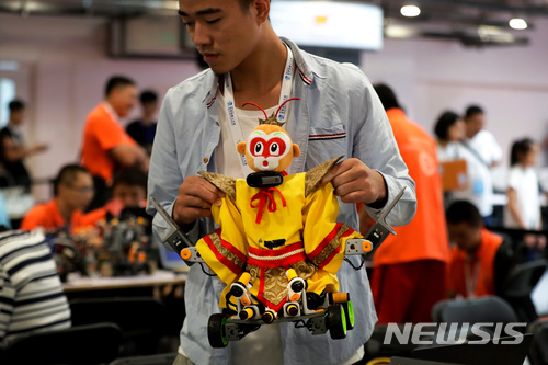 【베이징=AP/뉴시스】12일 중국 상무부가 “‘중국 제조 2025’ 전략은 투명하며, 자국 정부는 외국 기업에 기술 이전을 강요한 적이 없다”고 주장했다. 지난해 8월23일 중국 베이징 이촹국제컨벤션센터에서 개최된 '세계 로봇 컨퍼런스'에서 한 참가자가 손오공 이미지의 로봇을 들고 있다. 2018.04.12
