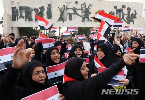 【바그다드(이라크)=AP/뉴시스】이라크 여성들이 지난 4월 수도 바그다드에서 이라크와 시리아 깃발을 들고 미국의 시리아 공격을 규탄하는 시위를 벌이고 있다. 2018.4.16