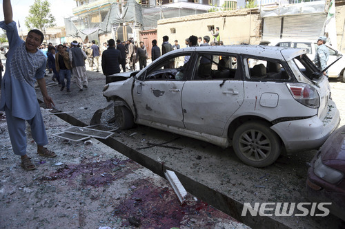 22일 아프간 수도 선거용 공민증 발급 센터 앞에서 벌어진 테러 현장에 사람들이 모여 서 있다. 31명이 사망했다. AP