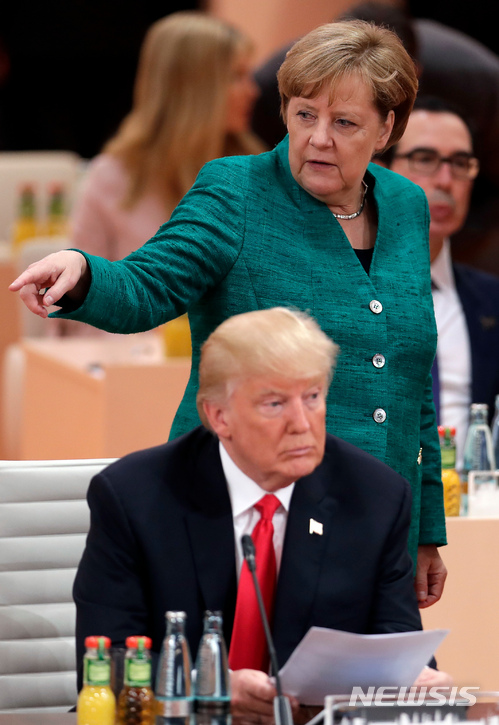 【함부르크=AP/뉴시스】앙겔라 메르켈 독일 총리(뒤편)가 2017년 7월 8일 독일 함부르크에서 열린 주요20개국(G20) 정상회의에서 도널드 트럼프 미국 대통령의 뒤에서 손짓하고 있다. 2018.4.27.