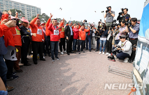 【서울=뉴시스】이영환 기자 = 14일 오후 서울 영등포구 여의도공원 문화광장에서 열린 소상공인 생존권 사수 결의대회에서 최승재 소상공인연합회장과 관계자들이 국회의사당이 나온 현수막에 숟가락을 던지는 퍼포먼스를 하고 있다. 2018.05.14.  20hwan@newsis.com 