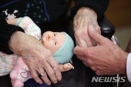 미국 미시간주의 한 양로원에서 아들이 늙은 어머니의 손을 잡고 있다. AP
