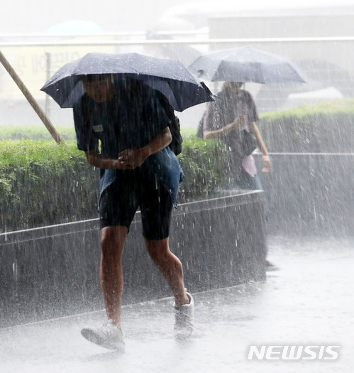【서울=뉴시스】박주성 기자 = 16일 오후 갑작스럽게 내린 폭우로 수요집회에 참석한 학생이 비를 피하고 있다. 2018.05.16. park7691@newsis.com