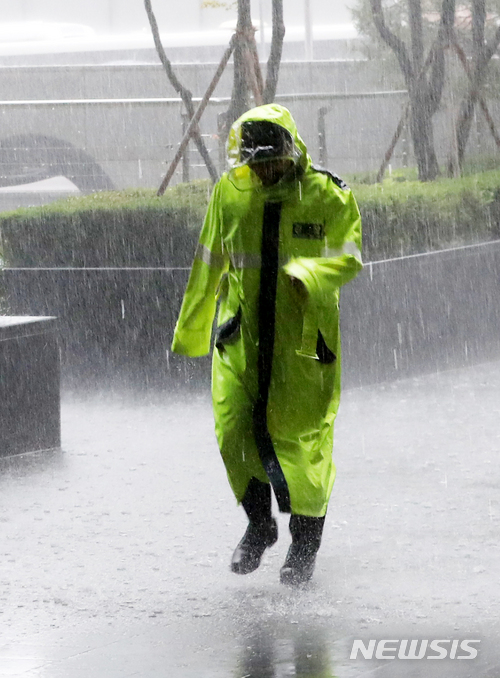 【서울=뉴시스】박주성 기자 = 16일 오후 갑작스럽게 내린 폭우로 수요집회에 투입된 경찰이 비를 피하고 있다. 2018.05.16.  park7691@newsis.com