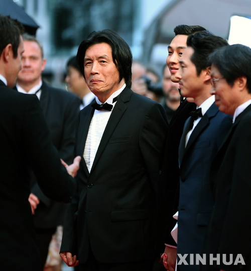 (180517) -- CANNES, May 17, 2018 (Xinhua) -- Director Lee Chang-dong (C) poses on the red carpet during the premiere of the film &quot;Burning&quot; at the 71st Cannes International Film Festival in Cannes, France, on May 16, 2018. The 71st Cannes International Film Festival is held from May 8 to May 19. (Xinhua/Luo Huanhuan) (zxj)