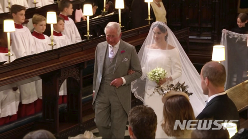 【런던=AP/뉴시스】19일(현지시간) 영국 윈저성에 있는 세인트 조지 교회에서 해리 왕자와 메건 마클의 '세기의 결혼식'이 열리는 가운데 마클은 시아버지인 찰스 왕세자와 함께 입장하고 있다. 2018.05.20 