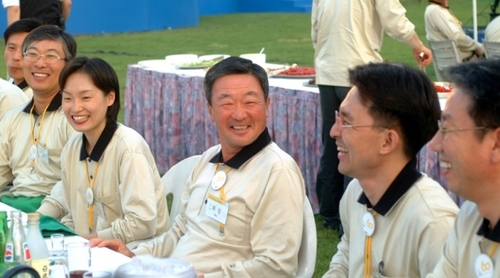 구본무 LG 회장은 직원들과 똑같이 행사로고가 새겨진 티셔츠를 입고 함께 어울렸다. 지난 2002년 5월 구 회장(가운데)이 한 행사장에서 직원들과 대화를 나는 모습. 사진=LG 제공