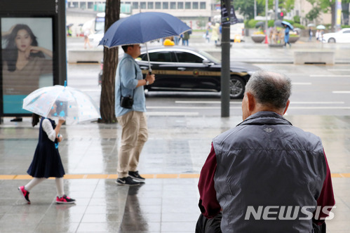 【서울=뉴시스】배훈식 기자 = 약한 비가 내리기 시작한 22일 오후 서울 종로구 세종문화회관 앞에서 한 시민이 비를 피하고 있다. 2018.05.22. dahora83@newsis.com