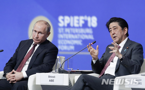 【상트페테르부르크(러시아)=AP/뉴시스】러시아를 방문한 아베 신조(安倍晉三) 일본 총리(오른쪽)가 25일 상트페테르부르크에서 열린 국제경제 포럼에서 블라디미르 푸틴 대통령과 이냐기를 나누고 있다. 2018.5.27