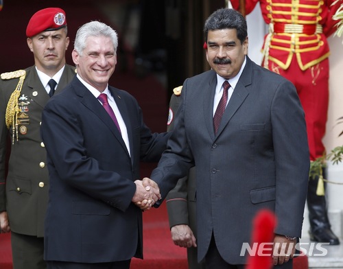 【카라카스( 베네수엘라) = AP/뉴시스】 지난 5월 30일 베네수엘라를 방문한 쿠바의 미겔 디아스카넬 국가평의회 의장 (왼쪽)이 니콜라스 마두로 대통령의 재선을 축하하면서 악수를 하고 있다.  