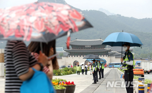 【서울=뉴시스】임태훈 기자 = 오존·자외선 농도가 전국적으로 나쁨 수준을 보인 8일 오후 서울 종로구 광화문 광장에서 경찰들이 햇볕을 피하기 위해 우산을 쓰고 있다. 2018.06.08.  taehoonlim@newsis.com