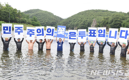 【울산=뉴시스】배병수 기자 = 더불어민주당 송철호 울산시장후보는 10일 울산시 울주군 범서읍 선바위 앞에서 사전투표율 20%초과에 따른 시민들과의 약속을 지키기 위해 입수를 한 뒤 수영동호인들과 함께 투표독려를 하고 있다. 2018.06.10. bbs@newsis.com.