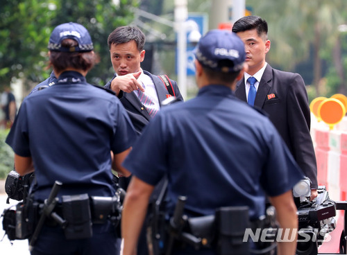 【싱가포르=뉴시스】박주성 기자 = 북미정상회담을 이틀 앞두고 김정은 북한 국무위원장이 싱가포르에 입국할 예정인 가운데 10일 오후 김정은 북한 국무위원장의 숙소로 유력한 싱가포르 세인트 리지스 호텔 앞에서 북한 취재진이 싱가포르 경찰과 이야기를 나누고 있다. 2018.06.10.  park7691@newsis.com