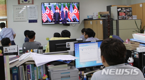 【화천=뉴시스】한윤식 기자 = 12일 싱가포르에서 세기의 북미정상 회담이 열리고 있는 강원 접경지역 지자체 공무원들이 두 정상간의 역사적인 만남의 순간을 시청하고 있다.2018.06.12. ysh@newsis.com 