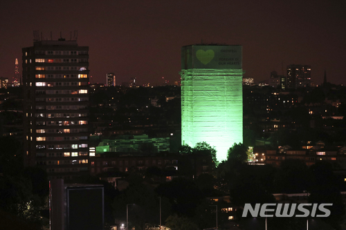 【런던=AP/뉴시스】72명의 생명을 앗아간 영국 런던 그렌펠 타워 화재 1주년을 맞아 14일 새벽(현지시간) 런던 서부 그렌펠 타워 외벽이 초록빛 조명으로 물들어 있다. 2018.6.14