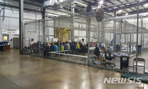 【매캘런(미 텍사스주)=AP/뉴시스】미 텍사스주 매캘런의 임시수용소에 미국으로 불법 입국하려다 체포된 사람들이 철창 안에 수용돼 있다. 이 사진은 미 관세국경보호청이 제공한 것이다. 2018.6.18