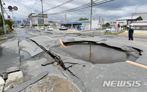 【오사카(大阪)=AP/뉴시스】진도 6약의 지진이 발생한 18일 일본 서부 오사카(大阪)의 한 도로에 발생한 균열에 수도관 파열로 새나온 물이 가득 차 있다. 이날 지진으로 오후 1시 현재 최소 3명이 사망하고 234명이 부상한 것으로 집계됐다. 2018.6.18