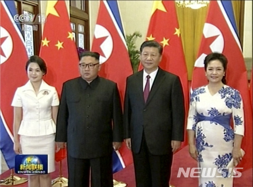 19일 방중한 북한 김정은 위원장이 부인 리설주와 함께 인민대회당 환영식에서 시진핑 주석 부부와 포즈를 취하고 있다. CCTV 장면    AP