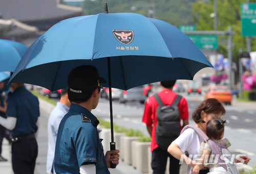 【서울=뉴시스】지난 6월22일 서울 광화문 광장에 배치된 의무경찰들이 햇빛가리개 용 우산을 쓰고 근무하는 모습. 2018.06.22. 