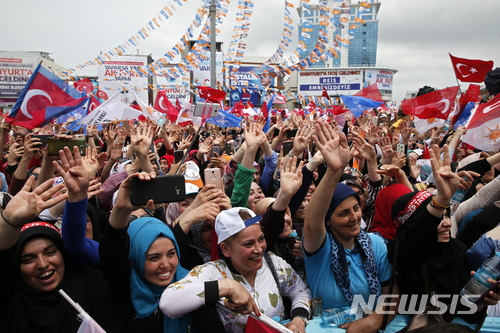 【이스탄불=AP/뉴시스】터키 대선 투표를 하루 앞둔 23일(현지시간) 이스탄불에서 레제프 타이이프 에르도안 대통령의 선거 유세가 열린 가운데, 그의 지지자들이 손을 흔들며 환영하고 있다. 2018.06.24.