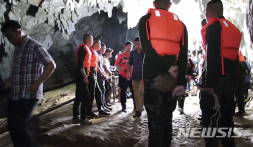 【방콕=AP/뉴시스】태국 북부에서 유소년 축구팀 소년 12명과 코치 1명이 관광 목적으로 동굴에 들어갔다가 실종돼 당국이 수색 중이다. 지난 24일 구조대원들이 동굴 입구에 모여 있는 모습. 2018.06.25
