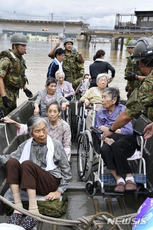 【구라시키=AP/뉴시스】폭우가 쏟아진 일본 오카야마 현 구라시키 시에서 8일 노인들이 구조되고 있다. 2018.07.08.