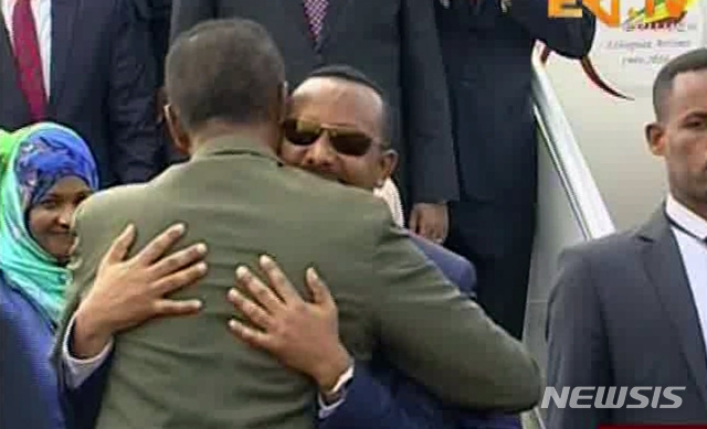 【에리TV 캡처=AP/뉴시스】아비 아흐메드(사진 가운데 선글래스 쓴 사람) 에티오피아 총리가 8일(현지시간) 에리트레아의 수도 아스마라 공항에 도착해 이사이아스 아페웨르키 대통령의 포옹을 받고 있다. 에티오피아와 에리트레아의 정상의 회동은 지난 1998년 국경전쟁이 터진 이래 20여 년만에 처음이다. 에티오피아 총리실은 이날 성명을 통해 "아흐메드 총리와 에리트레아 대통령 사이에 공통된 역사와 20년간 중단된 양국관계를 되살리는 회담이 열릴 것"이라고 밝혔다.사진은 에리트레아의 국영방송인 에리TV를 AP통신이 캡처한 것. 2018.07.09.