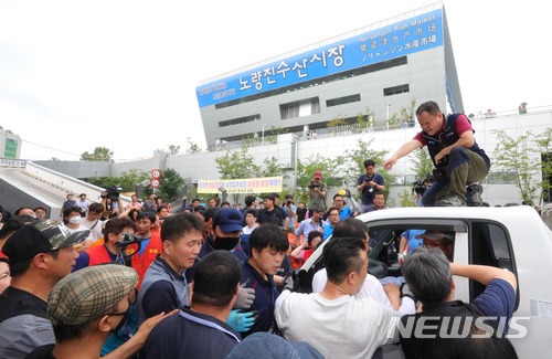 【서울=뉴시스】배훈식 기자 = 서울중앙지법이 구 노량진수산시장 불법 점유 상점에 대한 명도집행에 들어간 12일 오전 서울 동작구 구 시장 앞에서 상인들이 집행관들과 대치하고 있다. 2018.07.12.  dahora83@newsis.com