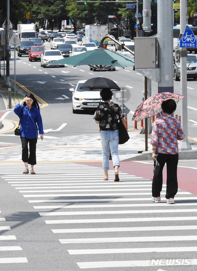 【대전=뉴시스】함형서 기자 =전국적으로 폭염경보가 발효된 23일 오후 대전 서구 둔산동사거리 앞에서 시민들이 손과 우산으로 햇빛을 가린채 길을 건너고 있다 . 2018.07.23.foodwork23@newsis.com