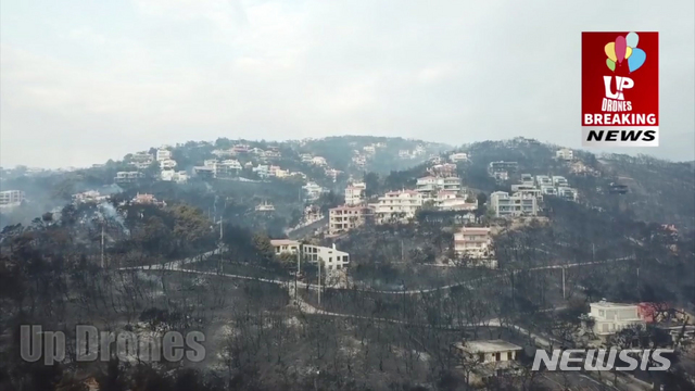 In this aerial view taken from a drone, showing the devastation caused by Greece wildfires, in the village of Mati, east of Athens, Tuesday, July 24, 2018. Wildfires have raged through seaside resorts near the Greek capital, torching homes, cars and forests and killing at least 50 people, authorities said Tuesday. (UP Drones via AP) DO NOT OBSCURE LOGO