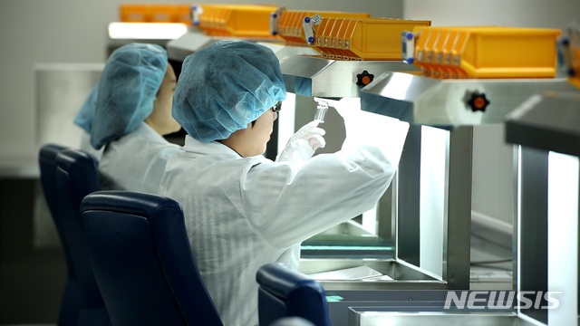  【서울=뉴시스】 삼성바이오로직스 직원들이 완제의약품에 대한 이물질검사를 하고 있는 모습.