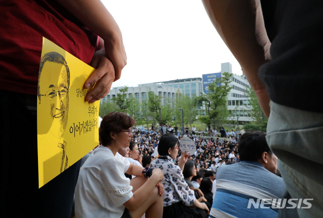 【서울=뉴시스】박주성 기자 = 지난 7월 서울 신촌 연세대학교 대강당에서 열린 고 노회찬 정의당 원내대표 추모제에 들어가지 못한 시민들이 대강당 앞 광장에서 추모제 영상을 보고 있다. 2018.07.26. park7691@newsis.com