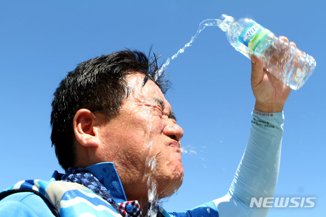 【화천=뉴시스】한윤식 기자 = 1일 오후 강원 화천 북한강 쪽배축제장에서 열린 화천군청 공무원 용선경주대회를 마친 공무원이 얼굴에 물을 뿌리며 더위를 식히고 있다. 이날 오후 2시 1분께 홍천 기온이 40.3도까지 치솟으며 우리나라 기상관측 역대 최고 온도를 기록했다. 2018.08.01.  ysh@newsis.com  