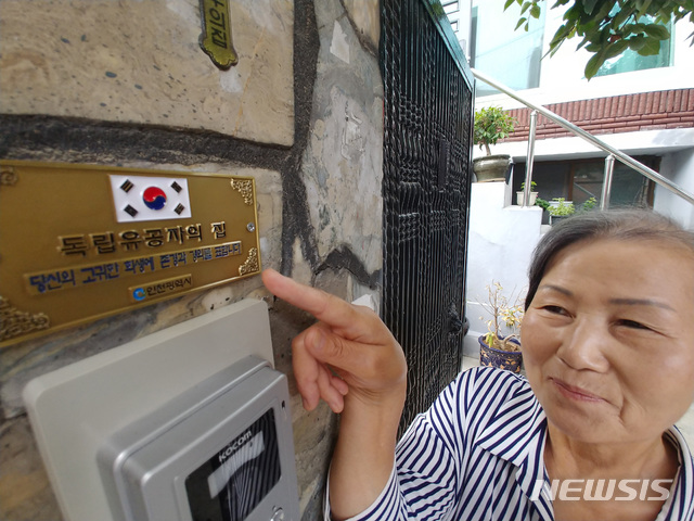 【인천=뉴시스】 이정용 기자 = 독립운동가 고(故) 홍창흠 애국지사의 딸 홍순옥(68)씨가 15일 오전 인천시 미추홀구 용현동 자택 대문 앞에 붙여진 '독립유공자의 집' 명패를 바라보고 있다.인천시는 이날 홍씨가 거주하는 자택 대문에 '독립유공자의 집'을 알리는 명패를 설치했다. 2018.08.15.stay@newsis.com