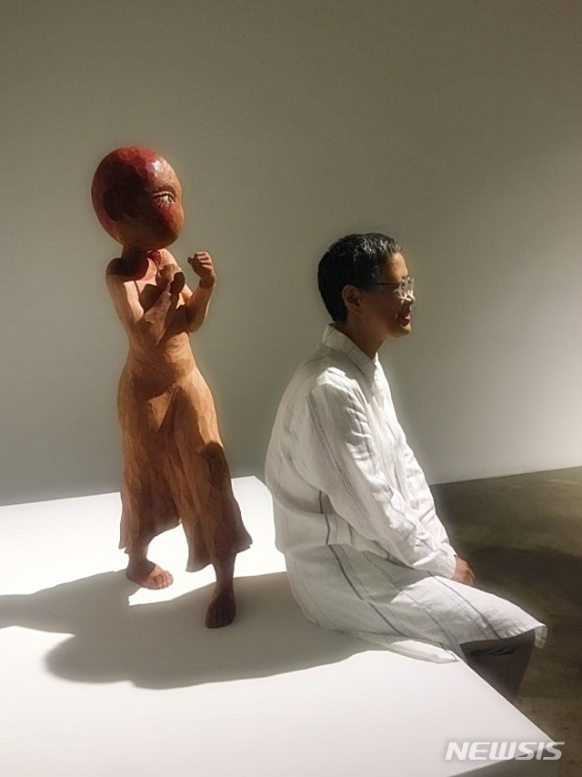 【서울=뉴시스】 박현주 미술전문기자 = 16일 아트사이드갤러리에서 송진화 작가가 주먹을 꽉 쥐고 '다 덤벼라'하는 조각 앞에서 편안하게 포즈를 취했다.