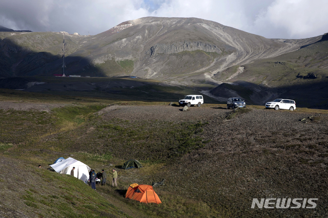 【백두산(북한)=AP/뉴시스】뉴질랜드의 로저 셰퍼드가 이끄는 외국 관광객들이 19일 백두산에서 트레킹 도중 텐트를 치고 캠핑을 준비하고 있다. 북한이 처음으로 안내원들의 정형화된 선전에 묶이지 않은 백두산 트레킹을 허용해 지난 18일 첫 여행이 시작됐다. 2018.8.20