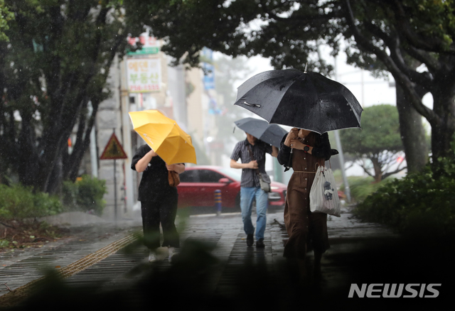 【제주=뉴시스】강정만 기자 = 제19호 태풍 솔릭이 23일 오전 제주도를 지나면서 시민들이 거센 비바람을 막아내며 출근하고 있다. 2018.08.23 kjm@newsis.com