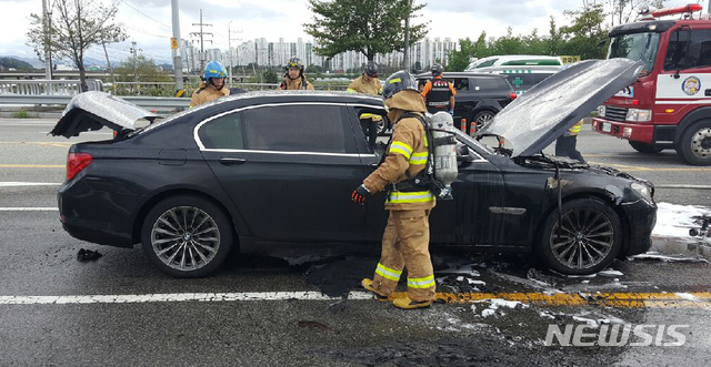 【대전=뉴시스】함형서 기자 = 30일 오후 대전 유성구의 한 도로를 달리던 BMW 750i 승용차에서 불이나 출동한 119소방대원들이 화재를 진화한 뒤 차량을 살펴보고 있다. 이 화재로 다행이 인명피해는 없다.화재가 난 BMW 750i 승용차는 휘발유 차량으로 리콜 대상이 아니다.경찰과 소방당국은 정확한 화재원인을 조사하고 있다. 2018.08.30.(사진= 대전지방경찰청 제공)photo@newsis.com