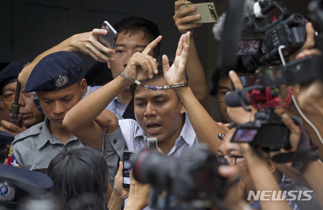 Reuters journalist Kyaw Soe Oo, center, talks to journalists during he is escorted by police as he leaves the court Monday, Sept. 3, 2018, in Yangon, Myanmar. A Myanmar court sentenced two Reuters journalists, Wa Lone and Kyaw Soe Oo, to seven years in prison Monday for illegal possession of official documents, a ruling that comes as international criticism mounts over the military&#039;s alleged human rights abuses against Rohingya Muslims. (AP Photo/Thein Zaw)