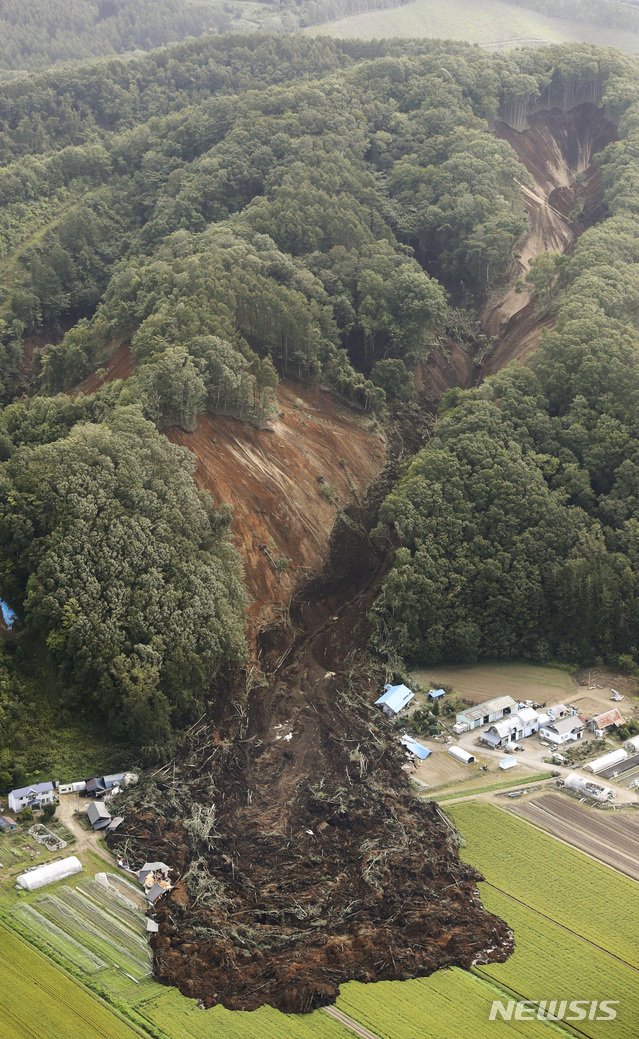 【 아쓰마=AP/뉴시스】  6일 새벽 3시 8분께 규모 6.7의 지진이 홋카이도(北海道)를 강타했다. 사진은 지진으로 아쓰마에서 산사태가 발생한 모습. 산의 일부분이 무너져 내리면서, 아래 쪽에 있던 집들을 덮쳤다. 2018.09.06 
