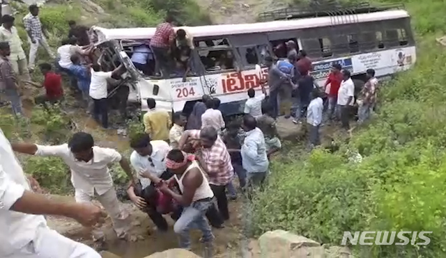 【자그티얄(인도)=AP/뉴시스】인도 텔랑가나주 자그티알 지역에서 11일 힌두교 순례객들을 가득 태운 버스가 계곡 아래로 추락한 사고 현장에서 행인 등이 부상자와 시신을 옮기고 있다. 이 사고로 55명이 목숨을 잃고 33명이 부상했다. 사고 버스는 정원을 초과해 많은 인원을 탑승시켰다. 2018.9.11