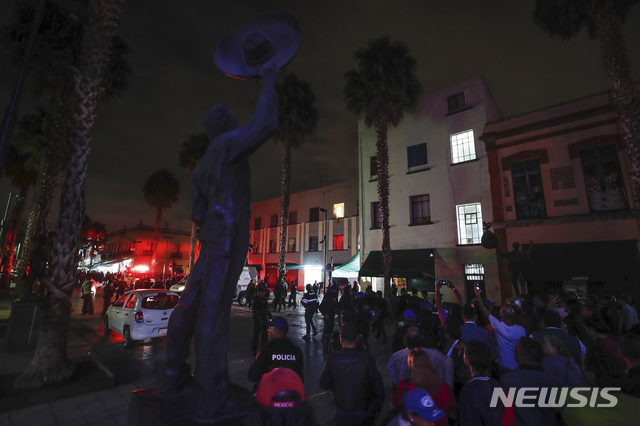 【멕시코시티 = AP/뉴시스】 멕시코 시티 중심가의 총기난사 사건이 발생한 가리발디광장에 14일 밤(현지시간) 사건 직후에 호기심에 찬 군중들이 몰려들면서 군경이 이들을 통제하고 있다.   